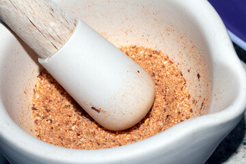 Close up of spices being ground in a pestle and mortar