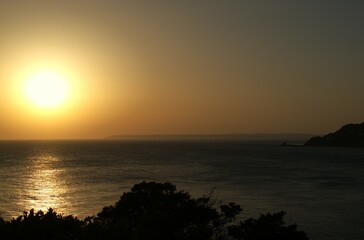 Sunset from the cliff of a seaside cove.