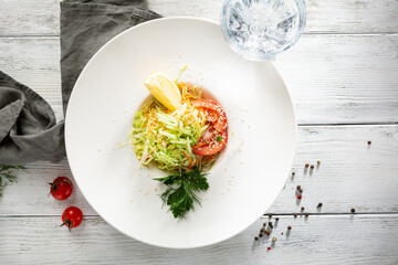Top view cabbage salad coleslaw with lemon in white bowl on rustiac table