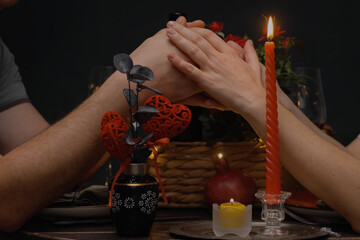 Romantic date. Loving couple tenderly hold hands during candlelit dinner on Valentine's Day.