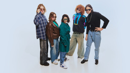 Stylish group of friends, men and women in 90s-inspired clothing, featuring plaid shirts, leather...