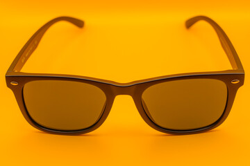 Stylish black sunglasses on vibrant yellow background