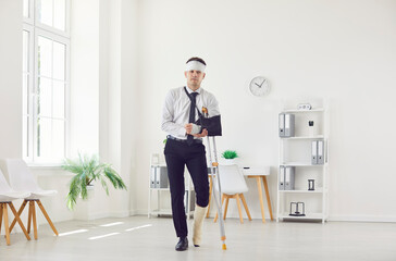 Full body portrait of male office worker with multiple body injuries. Young man with broken arm,...