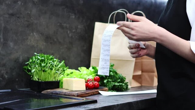 Bright produce and herbs lay ready as a cook examines a list for tonight's dinner. The air is filled with excitement for a flavorful meal full of fresh ingredients and creativity.
