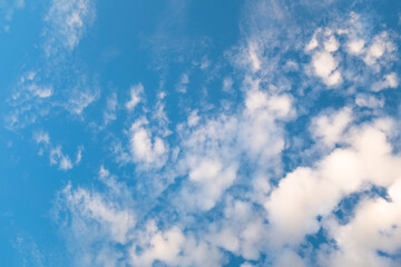 Obraz premium Blue Sky with Wispy Clouds at Sunset. This sky photo is perfect for backgrounds, themes of tranquility, nature, or freedom, and can be used in designs related to relaxation, inspiration or the outdoor