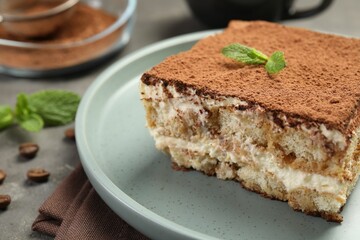 Piece of tasty tiramisu on grey table, closeup