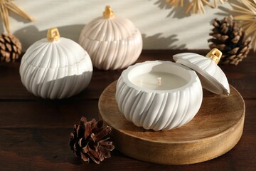 Soy wax candles and cones on wooden table. Beautiful christmas decor