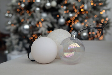 New Year's interior. White and silver New Year's balls on a blurred bokeh background. Close-up. Copyspace