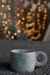 New Year's interior. White cup on blurred bokeh background. Close-up. Copyspace