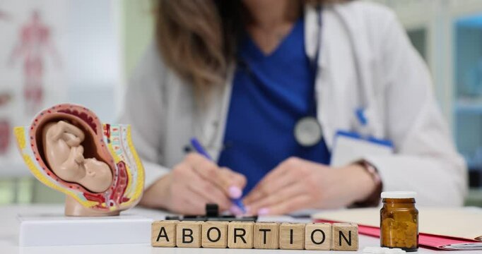 A medical professional discusses abortion using anatomical models and essential tools to enhance understanding