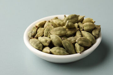 cardamom, spice consisting of whole or ground dried fruit 
Fragrant oriental spices cardamom pods  in a small white ceramic bowl  