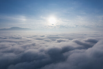 Naklejka premium Above of radiant sunlight over foggy and fluffy cloud in the morning
