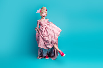 Full body portrait of medieval princess girl show shoes empty sapce wear luxury dress isolated on turquoise color background