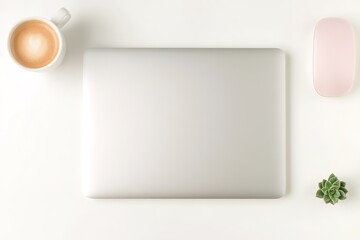 clean workspace featuring closed laptop coffee cup and small succulent on bright white desk illuminated by soft natural