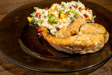 rice, vegetables and fish on dark plate
