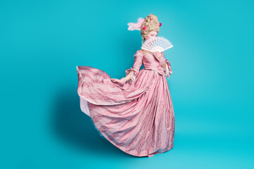 Photo of charming rococo duchess lady wear corset ball gown hold fan carnival isolated on blue color background