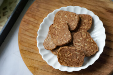 A close-up view of delicious chocolate almond cookies neatly arranged on a white plate.  A popular cookies in Malaysia during Eid Mubarak (Hari Raya)