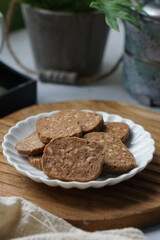 A close-up view of delicious chocolate almond cookies neatly arranged on a white plate.  A popular cookies in Malaysia during Eid Mubarak (Hari Raya)