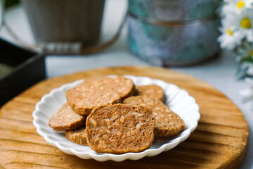 A close-up view of delicious chocolate almond cookies neatly arranged on a white plate.  A popular cookies in Malaysia during Eid Mubarak (Hari Raya)