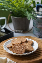 A close-up view of delicious chocolate almond cookies neatly arranged on a white plate.  A popular cookies in Malaysia during Eid Mubarak (Hari Raya)