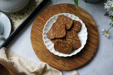 A close-up view of delicious chocolate almond cookies neatly arranged on a white plate.  A popular cookies in Malaysia during Eid Mubarak (Hari Raya)