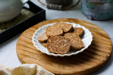 A close-up view of delicious chocolate almond cookies neatly arranged on a white plate.  A popular cookies in Malaysia during Eid Mubarak (Hari Raya)