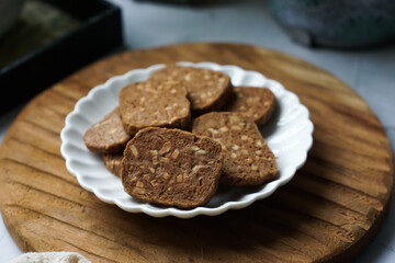 A close-up view of delicious chocolate almond cookies neatly arranged on a white plate.  A popular cookies in Malaysia during Eid Mubarak (Hari Raya)