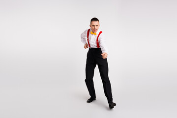 Energetic young man dancing in vintage style on white background with a focus on elegance and...