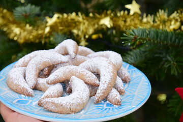 Homemade Vanillekipferl. Traditional German Christmas cookies on a plate in front of Christmas tree
