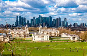 The Queen's House viewed from the Royal Observatory, showing the original house and the additional wings linked by colonnades. Behind are Canary Wharf's cluster of skyscrapers.