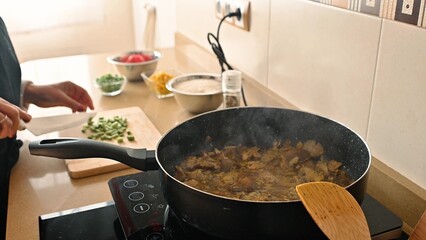 Cooking a traditional dish with fresh vegetables in a modern kitchen setup