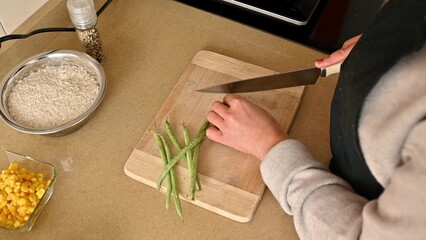 Preparing fresh green beans on a wooden board for a home-cooked meal