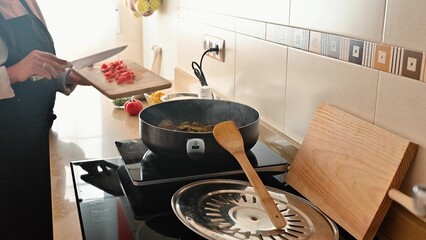 Person Cooking a Vegetable Dish in a Modern Kitchen Setting