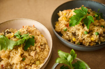 Delicious homemade vegetable rice dish with herbs served in ceramic bowls