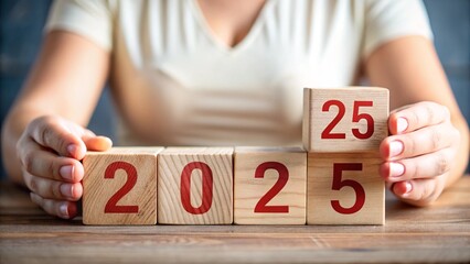 Woman hand hold wooden block with red numerical figures 2025 lined up. New year holiday and countdown concept.

