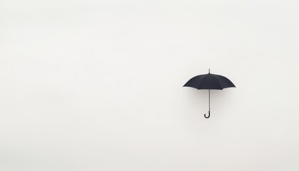 Black Umbrella Hanging Against Minimalistic White Background for Weather and Protection Themes