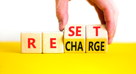 Reset and recharge symbol. Concept words Reset Recharge on beautiful wooden block. Beautiful yellow...