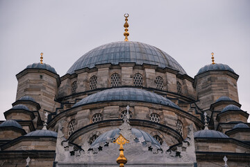 Featuring multiple domes and golden finials, the New Mosque or Yeni Valide Mosque presents a stunning skyline of Istanbul's intricate architecture, Turkey
