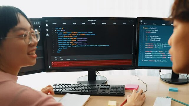Slow motion back end software developer engineer for computer programming working together on debugging writing computing code, solving complex algorithms display on monitor in office. Burgeoning