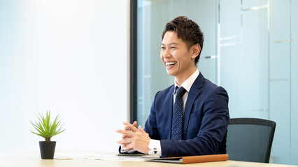笑顔で対話・商談をする男性ビジネスマン