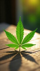 Single serrated green cannabis leaf on a wooden table with natural light, cannabis, leaf, light