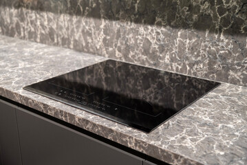 Modern black glass induction cooker on kitchen