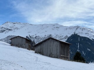 Old traditional swiss rural architecture and alpine livestock farms in the winter ambience of the alpine Swiss tourist resort Klosters - Canton of Grisons, Switzerland (Kanton Graub&uuml;nden, Schweiz)