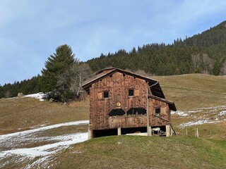 Old traditional swiss rural architecture and alpine livestock farms in the winter ambience of the...
