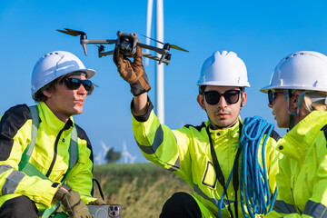 Engineers preparing drone for wind farm inspection