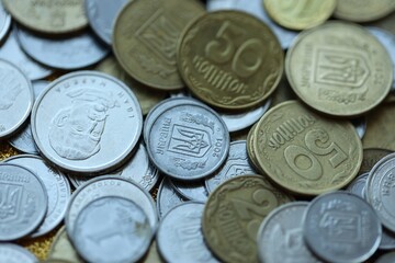 Metal coins of Ukraine of different denominations are scattered. Money texture, business background.