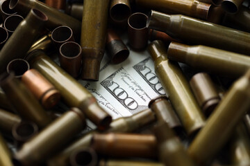 Many US dollar bills details seen through big amount of used cartridges