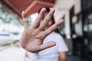 Close up of an open palm hand creates gesture of privacy, refusal, stop, or need personal space with bokeh background
