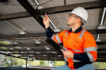Male maintenance engineer inspects the operation of solar panels and makes repairs.