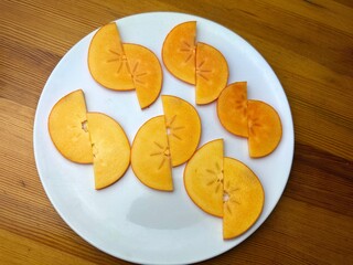 ripe persimmon fruits on a white isolated background persimmon fruits cut into slices